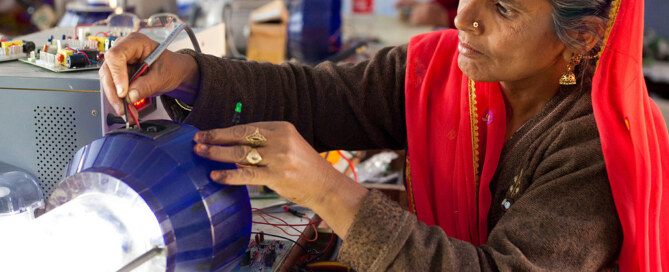 Woman repairs solar-powered lamp
