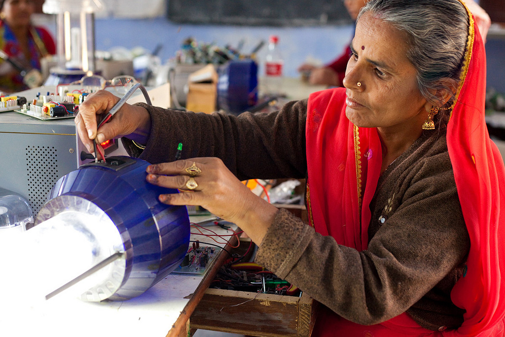 Woman repairs solar-powered lamp