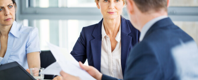 Senior businesswoman listens to her colleague during a staff meeting