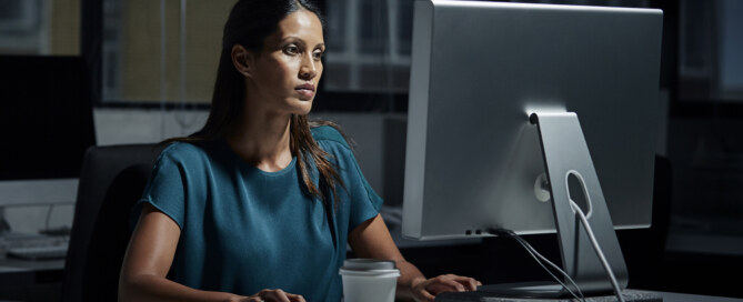 Businesswoman uses computer in dark office