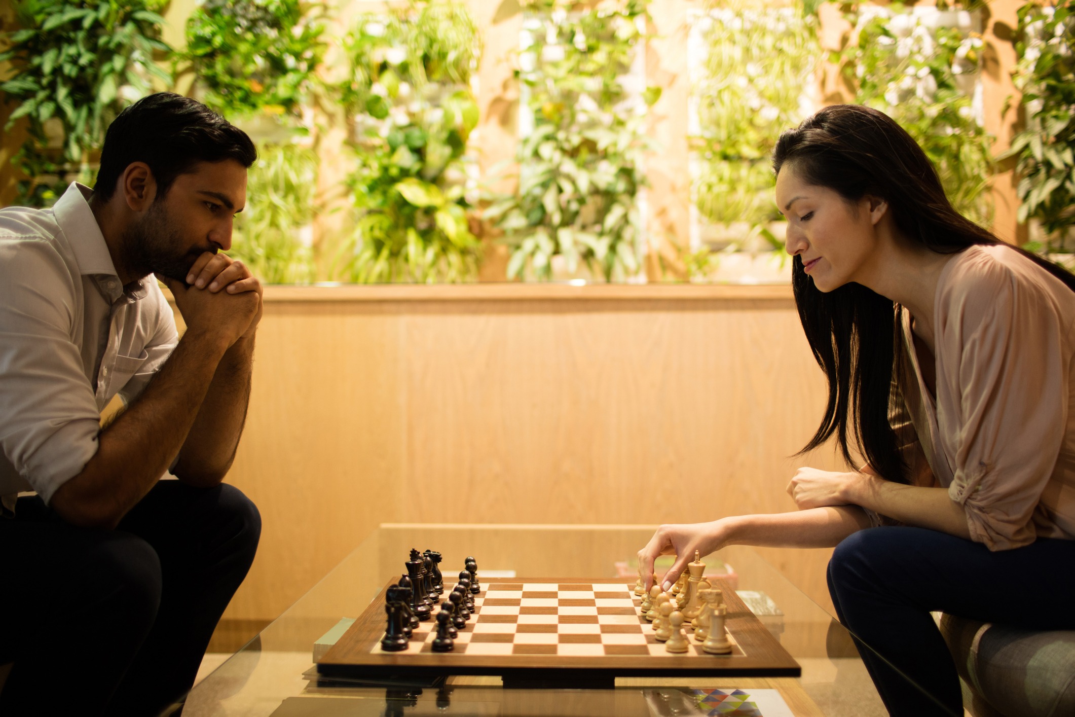 Business colleagues play game of chess in high-end hotel lobby