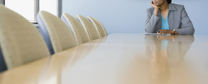 Business executive sits alone in boardroom