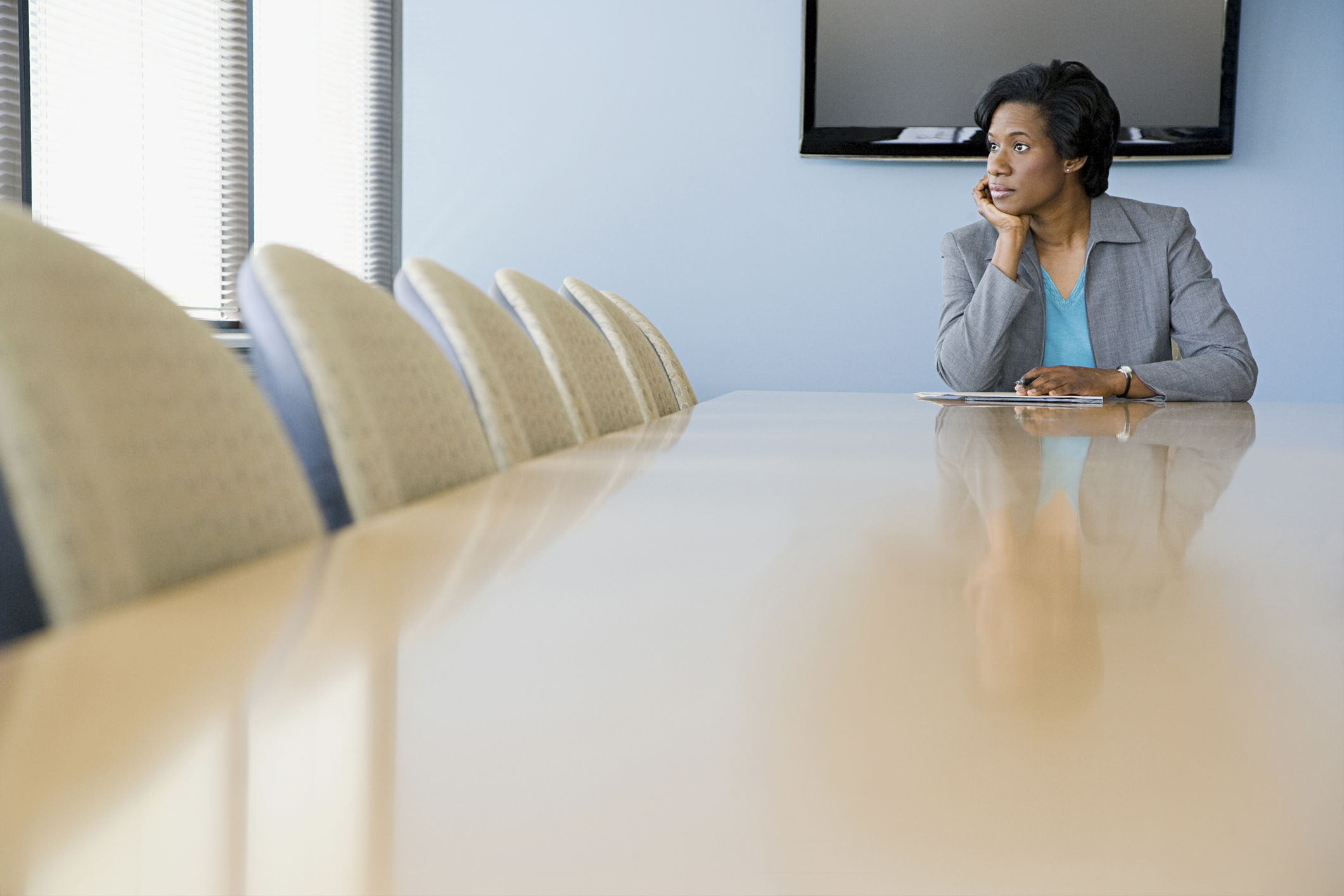 Business executive sits alone in boardroom
