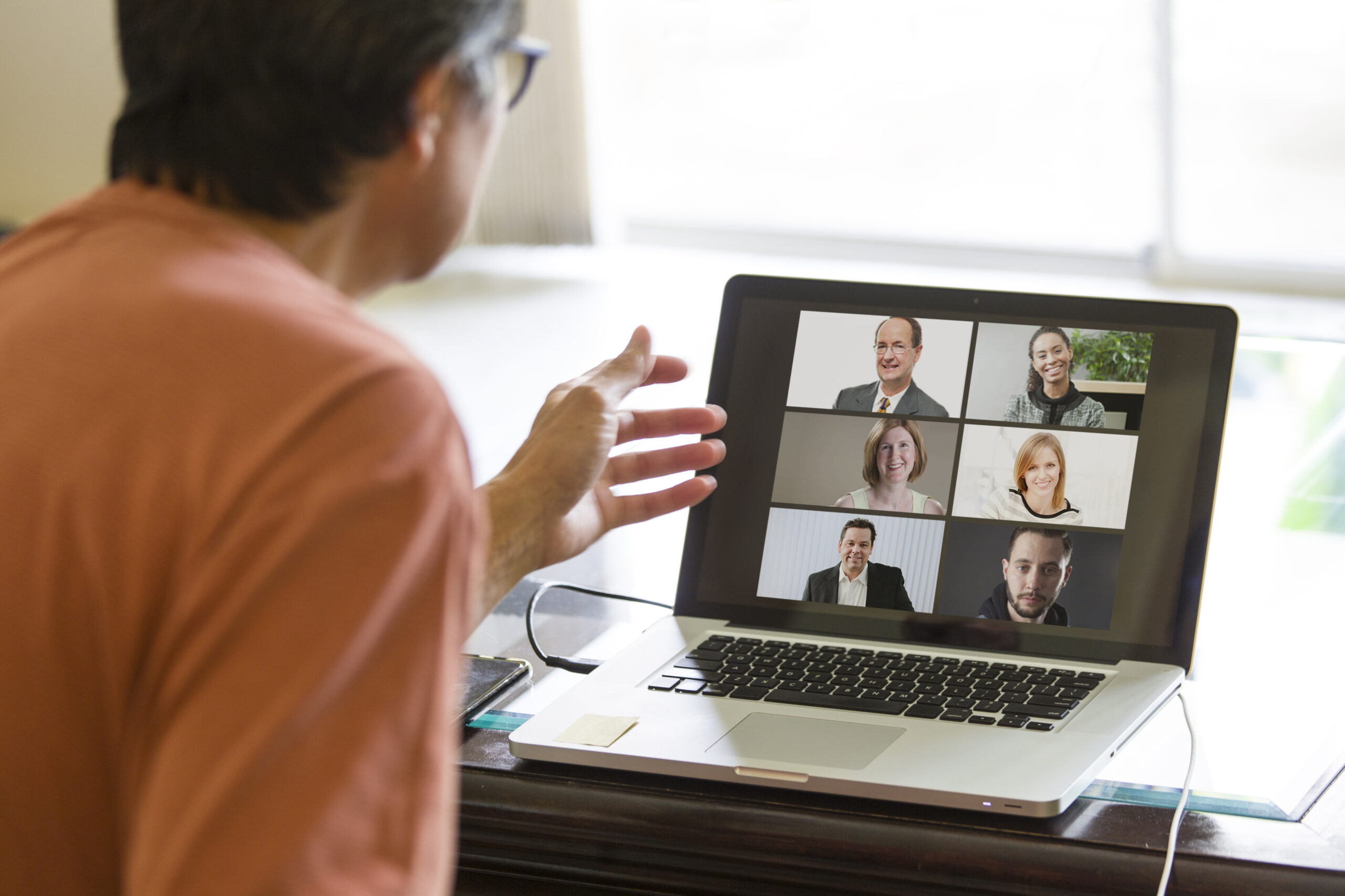 Remote team members hold meeting using virtual video conference software