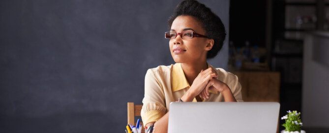 Young Black businesswoman works on laptop in home office
