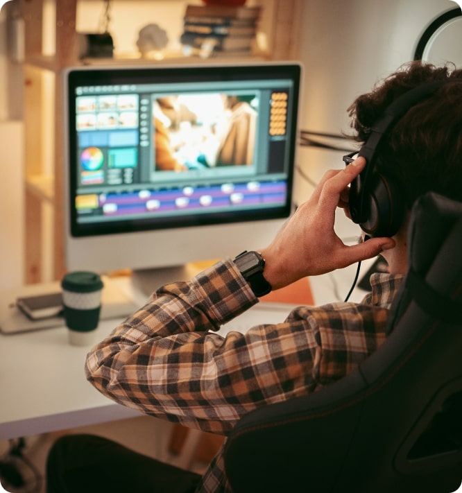 Designer sits at computer, working on explainer video