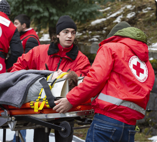 Red Cross Society volunteers transport an injured man on a stretcher