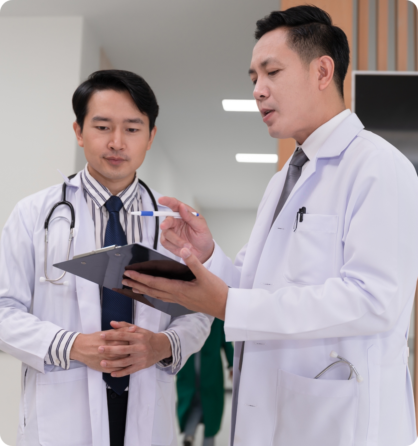 Asian-descent doctors conversing over a chart